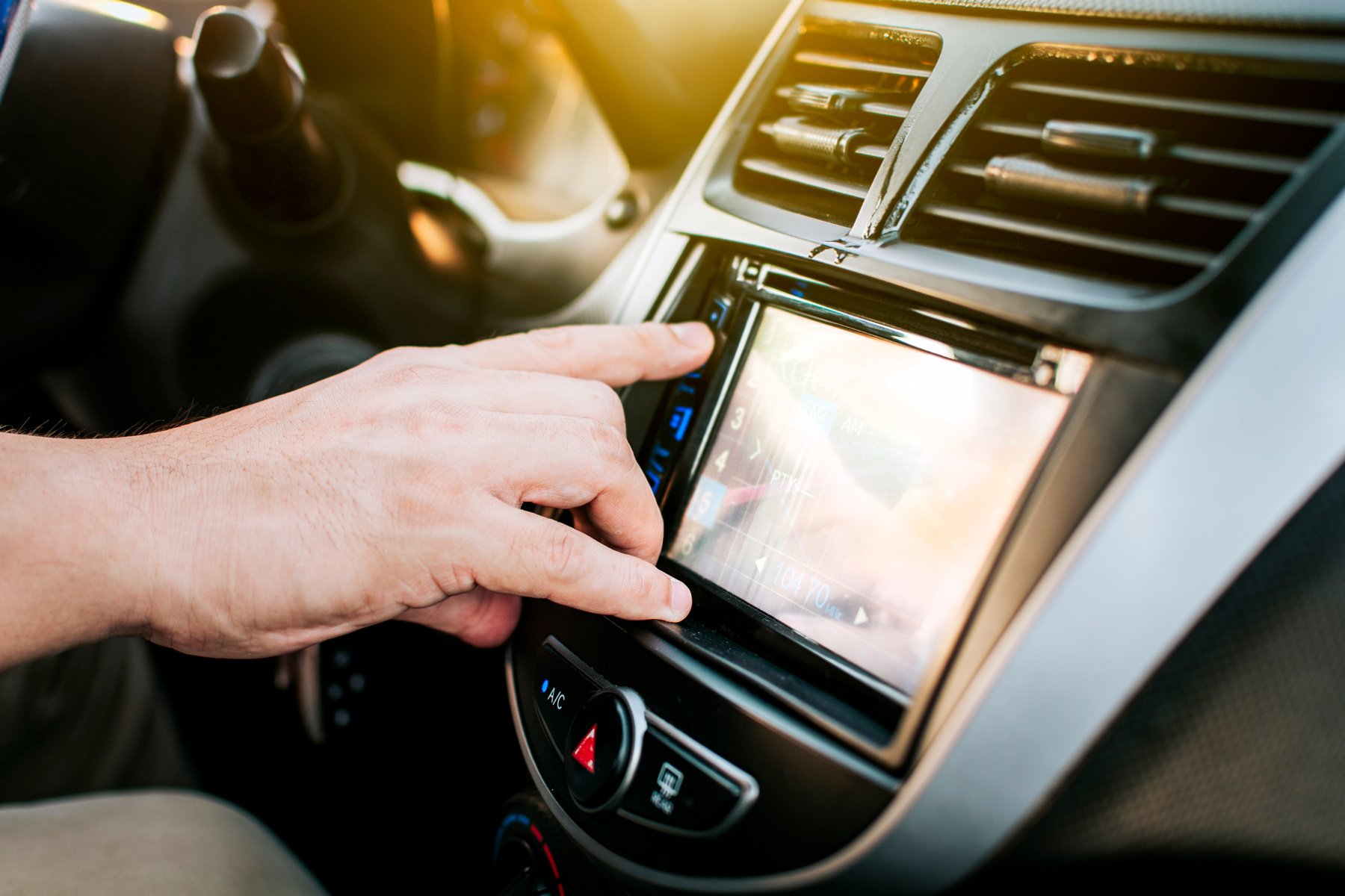 Driver hands changing the radio station. Close up of hands changing the car radio station. Concept of driver tuning the radio. Driver man changing radio station